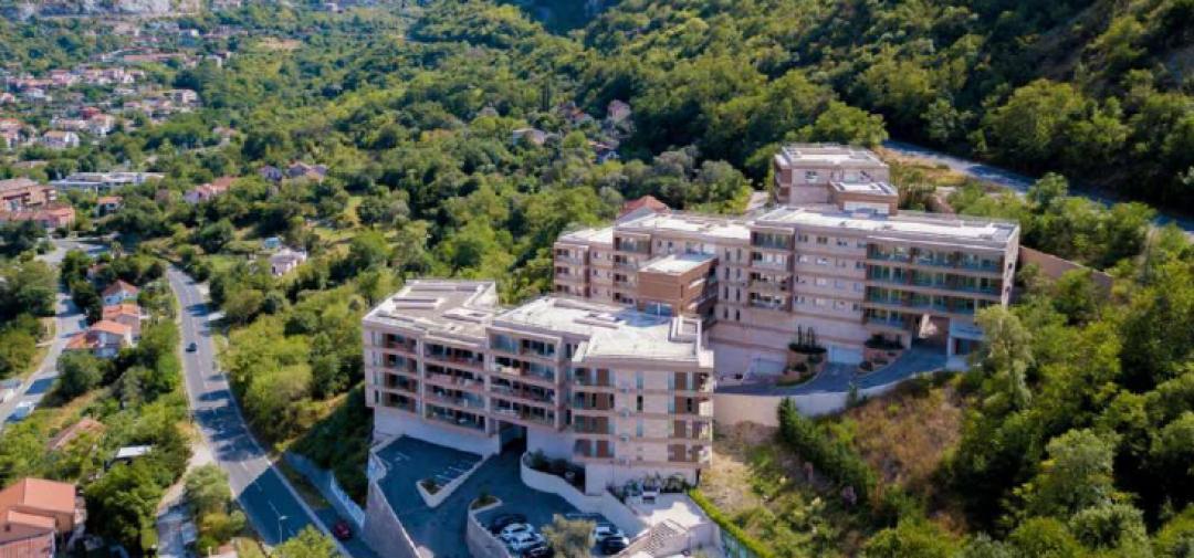 <p>Kotor'un tarihi Eski Kent bölgesine sadece 2 km uzaklıkta, Boka Körfezi'nin ışıltılı kıyısında ideal bir konuma sahip prestijli bir konut kompleksi olan projeye hoş geldiniz. Akdeniz cazibesini modern zarafetle harmanlayan proje, göz alıcı Adriyatik kıyılarıyla çevrili, zarif bir yaşam tarzı sunuyor.</p><p>Bu eşsiz proje, her biri depreme dayanıklı betonarme ve 7.500 m²'den fazla doğal Travertino Verona taşıyla kaplı, mimari açıdan uyumlu 5 binadan oluşmaktadır. Binanın altında, yıl boyunca konfor ve enerji verimliliği için termal köprü teknolojisiyle tasarlanmış, sofistike dört katmanlı bir termal, hidro ve ses yalıtım sistemi bulunmaktadır.</p><p>Proje, 35 m²'lik stüdyo dairelerden 232 m²'lik geniş çatı katlarına kadar uzanan 37 adet güzelce tamamlanmış daireye sahiptir. 22 farklı kat planıyla, rahat müstakil evlerden kalabalık aile evlerine kadar her yaşam tarzına uygundur. Her konut, aşağıdakiler de dahil olmak üzere yüksek kaliteli malzemelerle donatılmıştır:</p><p>Premium ahşap parke zeminler</p><p>Porcelanosa granit seramik karolar</p><p>Villeroy & Boch ve Noken sıhhi tesisat</p><p>Dahili havalandırma sistemli çift camlı ahşap pencereler</p><p>Yüksek hızlı optik internet ve uydu TV</p><p>Ortalama yatak odası boyutları 22 m²'dir ve tüm daireler, doğal ışığı ve deniz manzarasını en üst düzeye çıkarmak için özenle tasarlanmış yerleşim planlarına sahiptir. Seçili çatı katları iki katlıdır ve koy manzaralı özel teraslara sahiptir.</p><p>Sadece birkaç dakika uzaklıkta, Roma dönemi tarihiyle zengin bir UNESCO Dünya Mirası Alanı olan ve 28 ünlü deniz ürünleri restoranına, hareketli pazarlara ve bir yat limanına ev sahipliği yapan Kotor Eski Kent'in Arnavut kaldırımlı sokaklarını keşfedin. Doğa severler, bitişikteki 5 km'lik orman yürüyüş parkurunun ve panoramik dağ manzarasının keyfini çıkaracaklar.</p><p>Tivat Uluslararası Havaalanı sadece 8 km, AB sınırı ise kapınızın önünden sadece 60 km uzaklıkta olup, hem tatil hayatı hem de uzun süreli ikamet için mükemmel bir konumda yer almaktadır.</p>