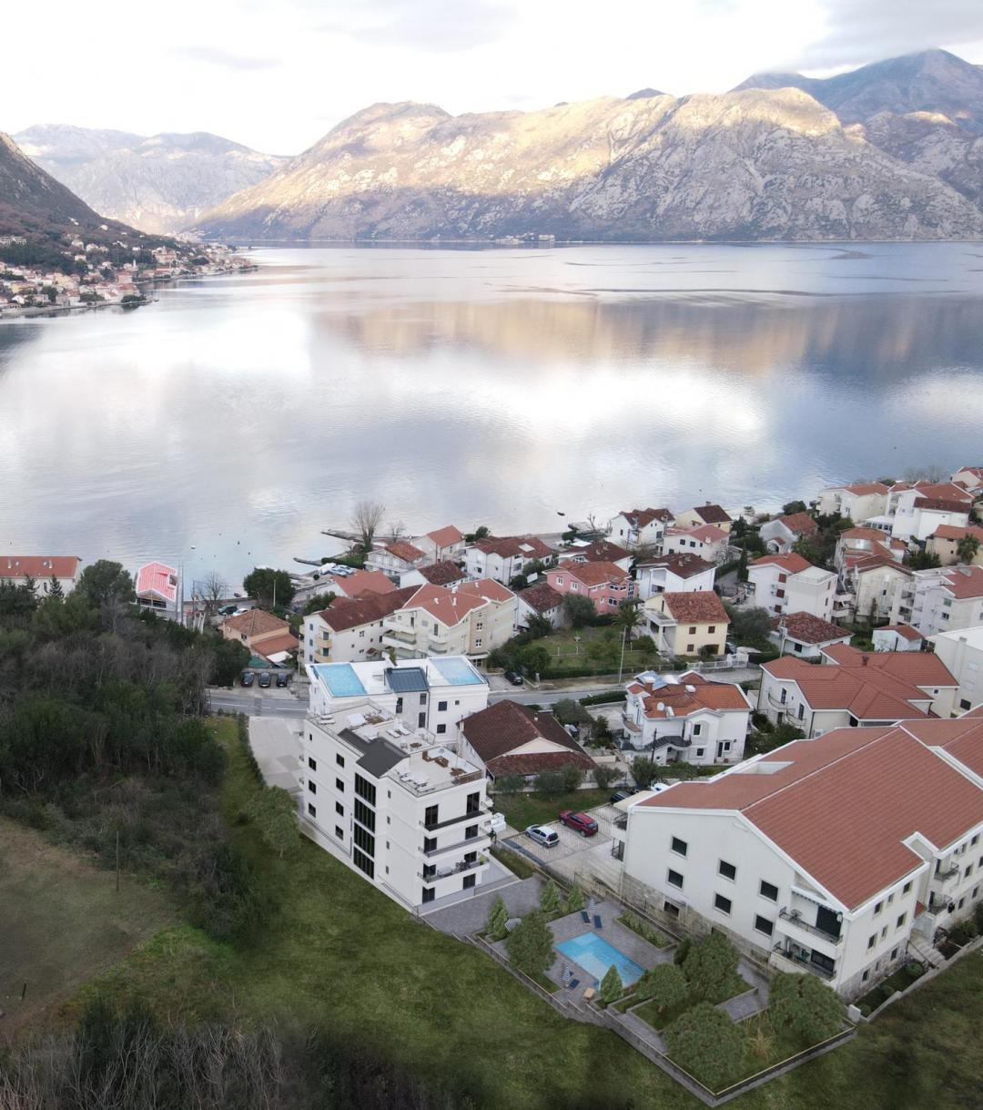 <p>Kotor Körfezi’nin muhteşem manzaralı kalbinde yer alan bu özel konut projesi, Dobrota’da Akdeniz yaşamının gerçek özünü deneyimleme fırsatı sunmaktadır. UNESCO koruması altındaki Kotor Eski Şehri’ne sadece birkaç dakika uzaklıkta ve Adriyatik Denizi’nin nefes kesici manzarasına sahip olan bu gelişim, zamansız doğal güzellik ile modern konfor ve kullanım kolaylığını bir araya getiriyor.</p><p>Zengin tarih, büyüleyici sahil kasabaları ve denizin sakinleştirici etkisiyle çevrili olan proje, huzurlu bir yaşam tarzı arayanlar, tatil kaçamağı yapmak isteyenler veya Avrupa’nın en güzel bölgelerinden birinde akıllıca yatırım yapmak isteyenler için mükemmel bir konum sunmaktadır.</p><p><strong>Temel Özellikler:</strong></p><p>Dobrota’da, denize sadece birkaç adım mesafede birinci sınıf konum</p><p>Kotor Körfezi’nin panoramik deniz manzarası</p><p>Şık ortak yüzme havuzu</p><p>Geniş iki ve üç odalı daireler</p><p>Seçili birimler için özel çatı terasları</p><p>Güvenli site içi otopark</p><p>Modern finisajlarla yüksek kaliteli inşaat</p><p>Akdeniz bitki örtüsü ve doğal güzelliklerle çevrili</p><p><strong>Yaşam Tarzı ve Çevre:</strong></p><p>Akdeniz kültürünün dengeli yaşam tarzından ilham alan bu proje, sadece yaşanacak bir yer değil; dinlenmek, bağlantı kurmak ve gelişmek için bir mekandır. Günlerinizi havuz kenarında dinlenerek, sahil boyunca yürüyüş yaparak veya aile ve arkadaşlarla yerel mutfağın ve şarapların tadını çıkararak geçirebilirsiniz. Sakin çevre ve ılıman iklim, burayı yıl boyunca ideal bir destinasyon haline getiriyor.</p><p>Tivat Havalimanı ve diğer bölgesel merkezlere mükemmel bağlantı sayesinde, Dobrota sessiz ama erişilebilir bir konum olarak uluslararası ilgiyi çekmeye devam etmektedir.</p>